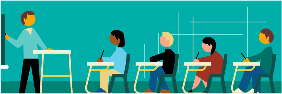 Students sitting in the classroom, looking at the teacher in front of the board